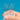 Set of small paintbrushes held between fingers against a blue background