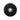 Round black pad with textured surface and central metallic component on a white background